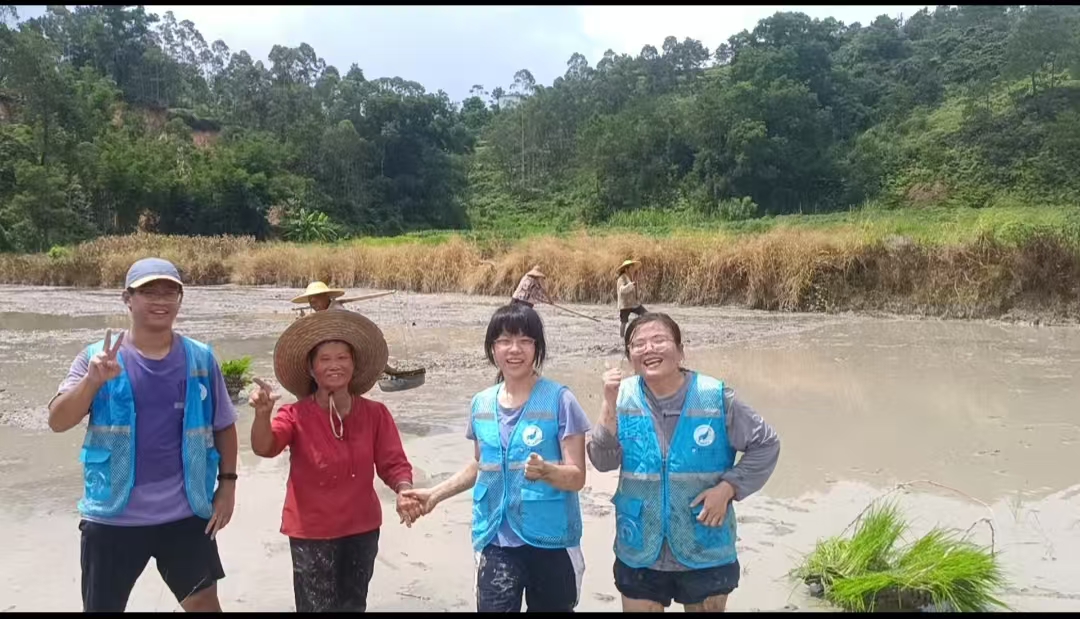 实践团成员与村民在红黑米田间合影